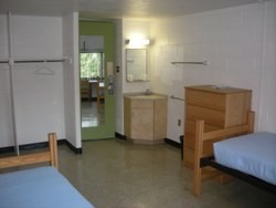 View of two beds, desk and open closets in a Good Counsel Hall double room.