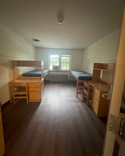 View of a bed, desk and wardrobe in a Moriarty Hall double room.