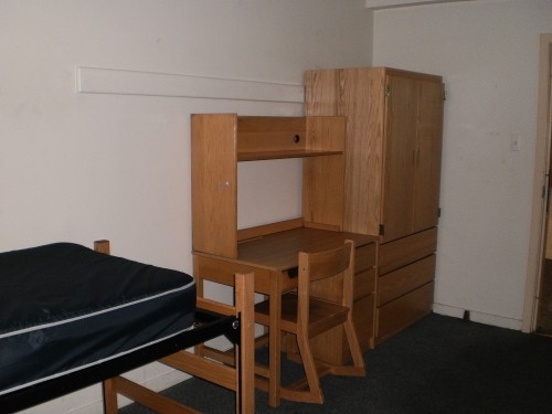 View of a bed, desk and wardrobe in a Moriarty Hall double room.