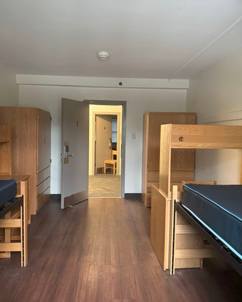 View of a bed, desk and wardrobe in a Moriarty Hall double room.