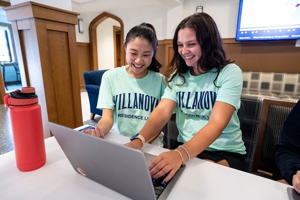 Two resident assistants check in students during Move-In Day