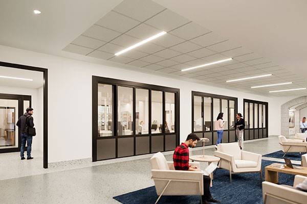 Rendering of a communal lounge area with student sitting and standing. Through internal windows, a lab space is visible.