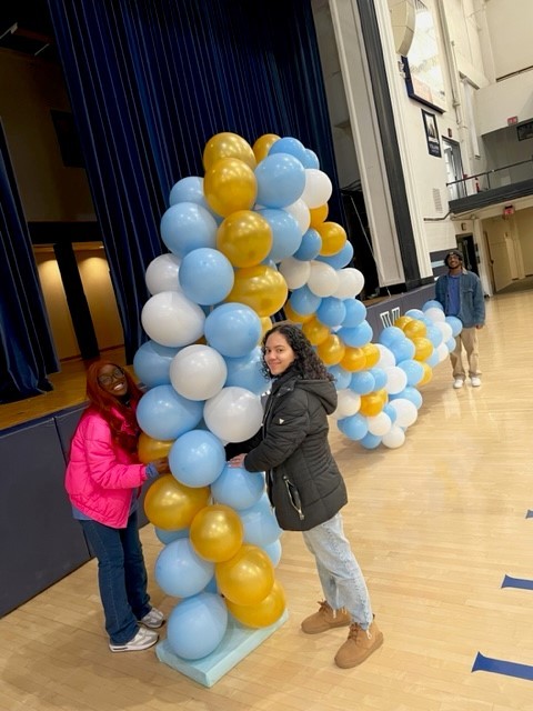 Two students create a balloon arch for the MLK Day of Service