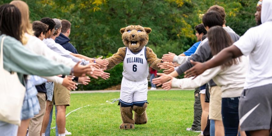 Will D. Cat giving students high fives in a line.