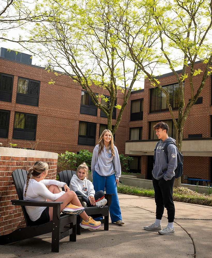 Students chatting outside of a residence hall.