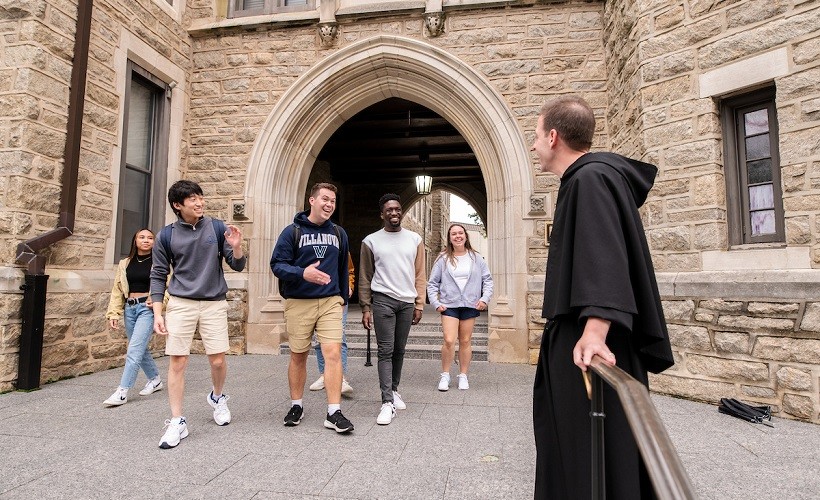 An Augustinian priest greets a group of Villanova students