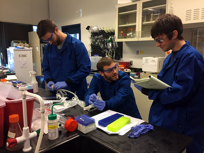 Graduate students Devon Zimmerman, Kyle Spivack and Matthew Nicholas analyze the cell culture bag for surface modifications. 