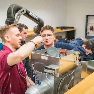 Mark Leach (left), Project Manager at Siemens, works with student Tim Filos work on Regulating Variable-Air-Volume Valves for a HVAC system (March 2019)