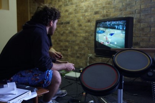 two men seated playing a video basketball game