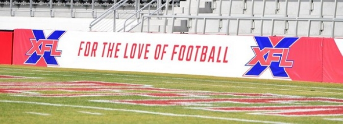 white banner on stadium wall reading XFL for the law of football in red lettering