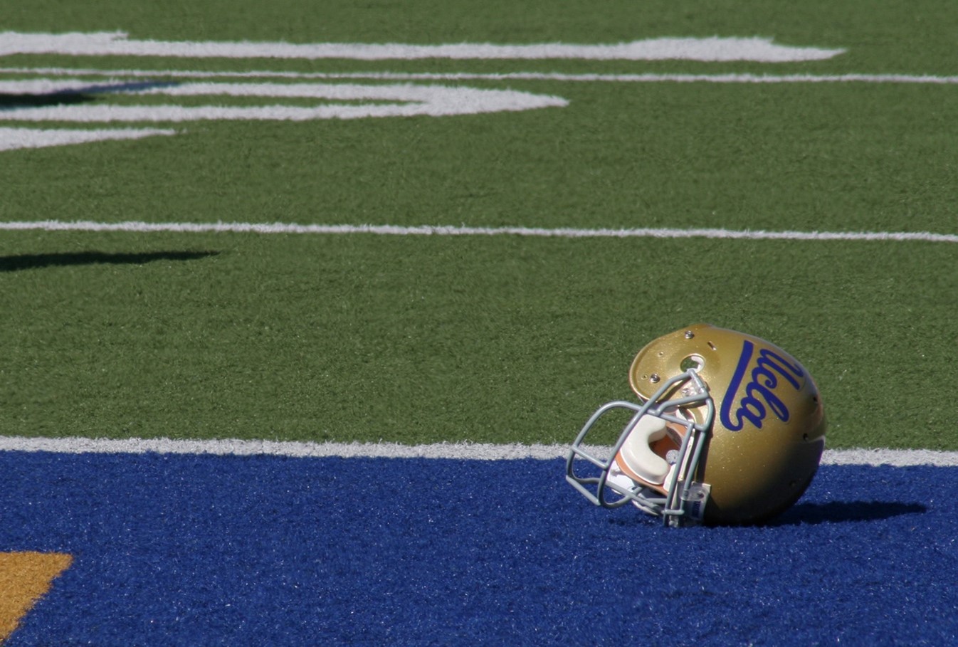 UCLA helmet laying in endzone on a football field