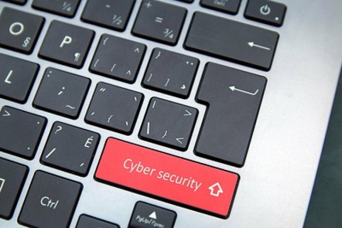 laptop keyboard with black keys except for red key stating cyber security in stead of the usual shift key 
