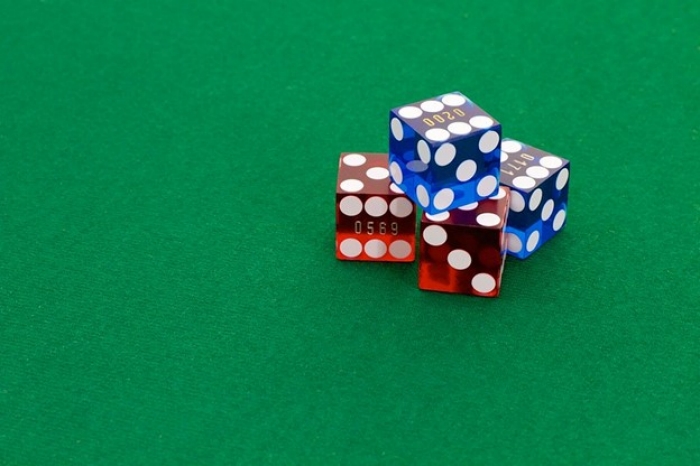 Stack of read and blue plastic dice on a green card table
