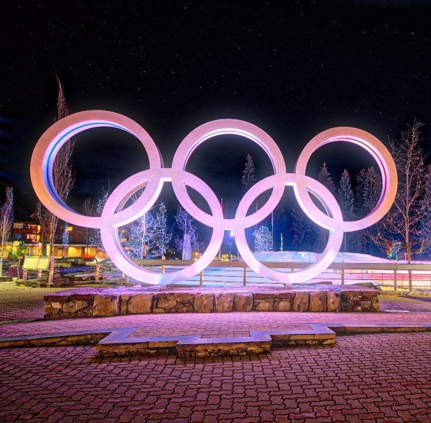 statute of Olympic Rings from Whistler lit up at night with purple lights