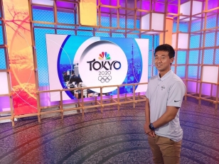Alex Whang posing on the NBC Sports set in Tokyo