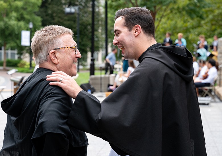 Two Augustinian friars chatting and laughing
