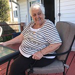 older woman smiling and sitting on porch