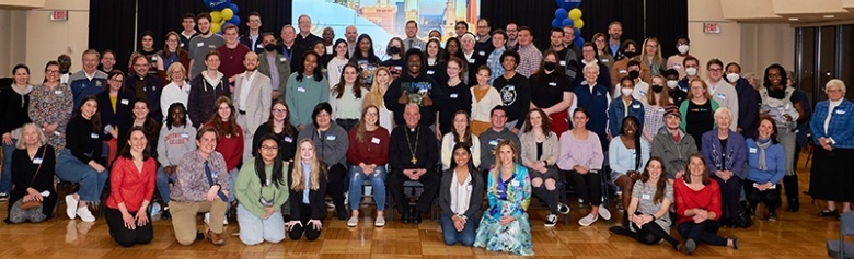 large group of college students and adults with archbishop of Philadelphia in the center