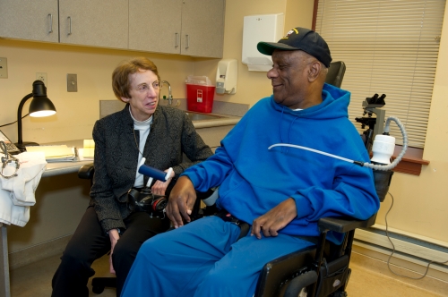 Dr. Smeltzer with man in wheelchair.