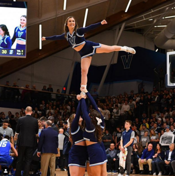 Madison Puleo balances on the hands of her fellow cheerleaders.