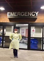 Female nurse stands outside Emergency Department.