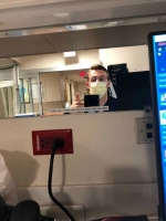 Male nurse with glasses and a mask over his face.