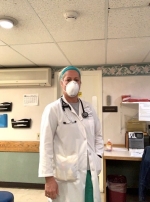 Female Nurse wearing a mask over her face in the clinical setting.