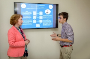 Male Student Reviewing Research with Professor
