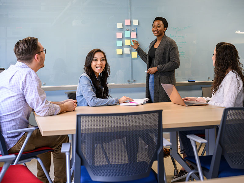 Student giving presentation in front of whiteboard