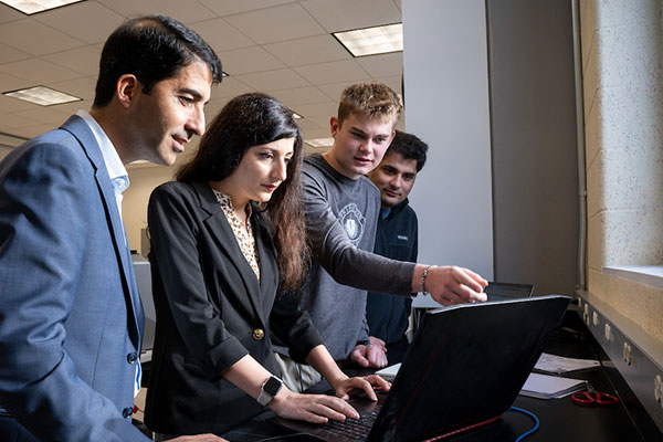 Mojtaba Vaezi, PhD, collaborates with students and colleagues in the College of Engineering’s Wireless Networking Laboratory.