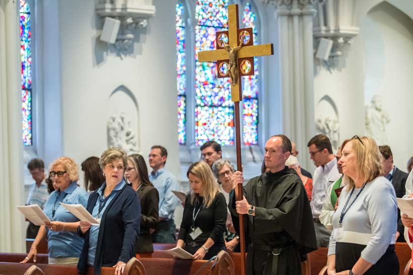 people in a church singing with a priest