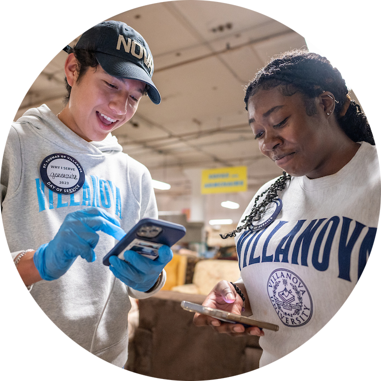 Two students smiling down at their phones