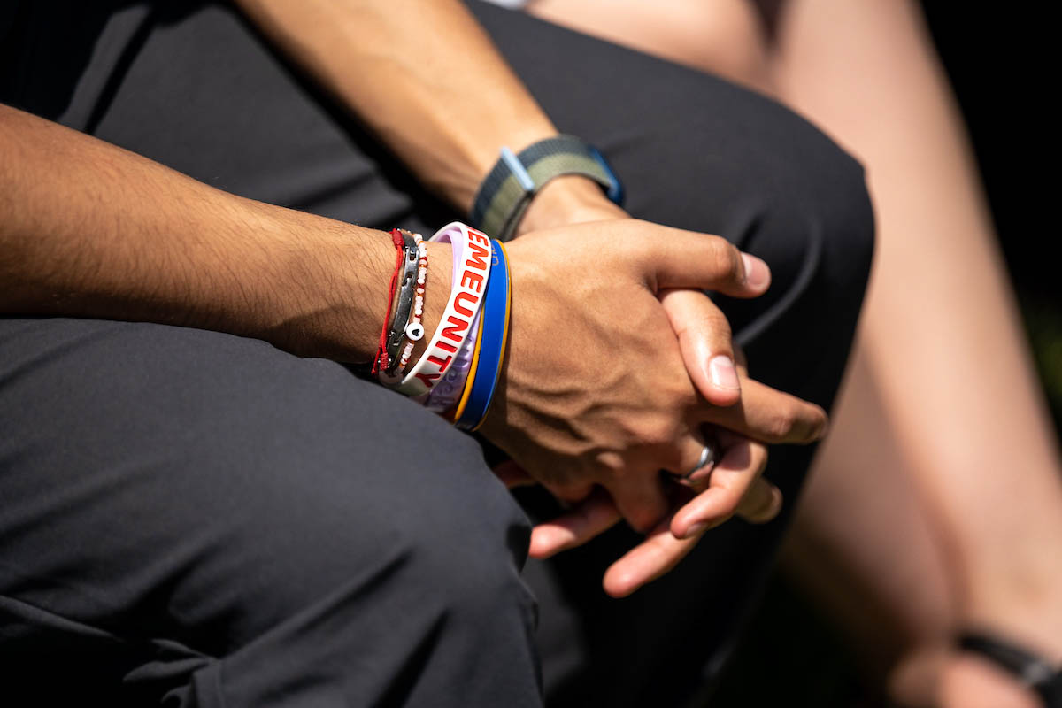 A close up of a person sitting with their hands clasped