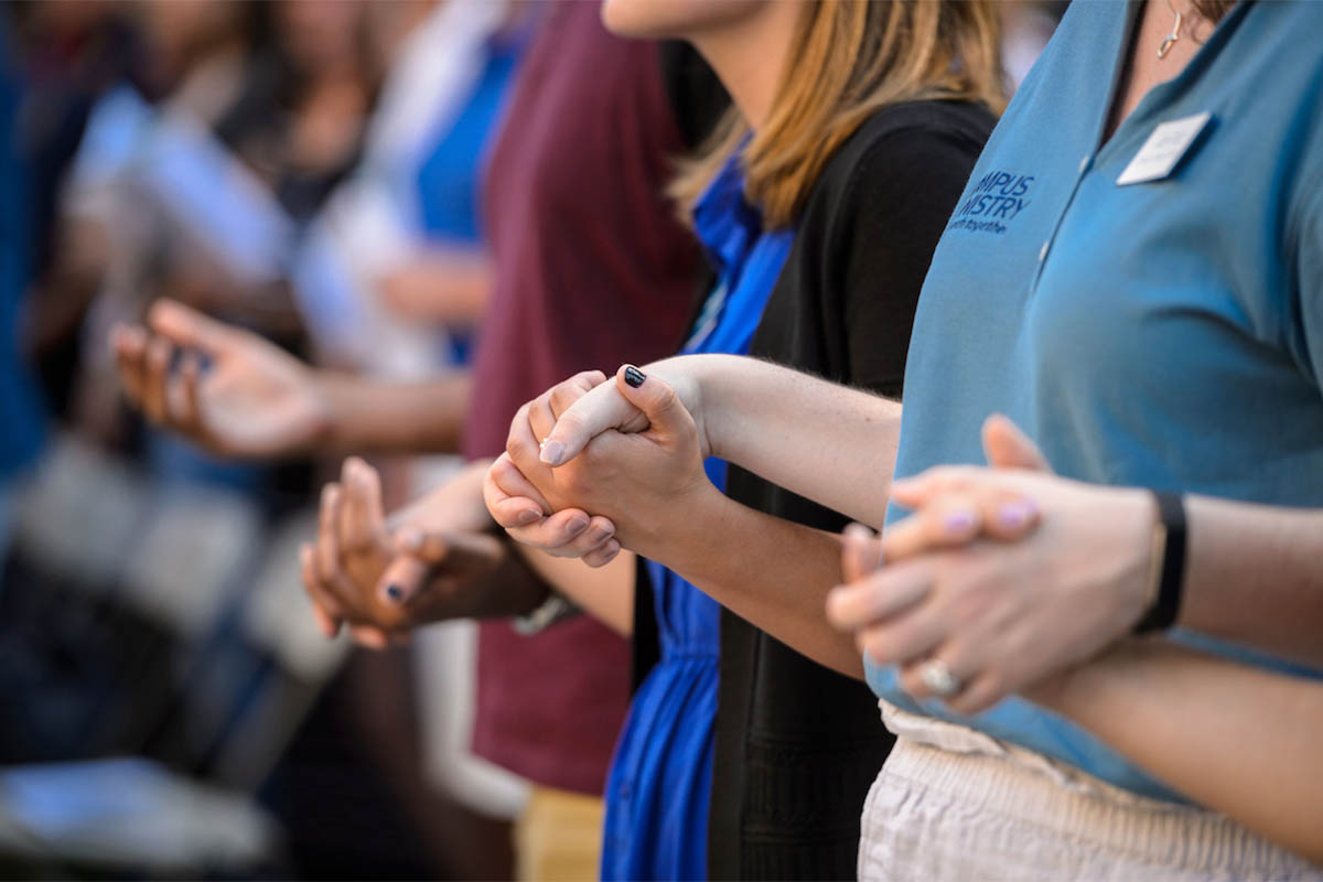 A close up of students holding hands