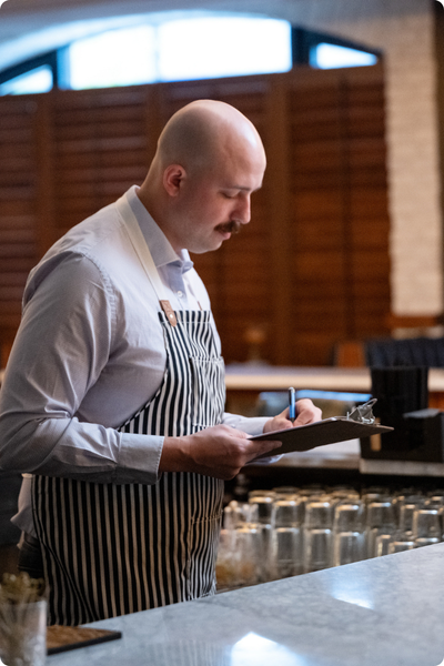 woman standing and holding a laptop looking at camera smiling