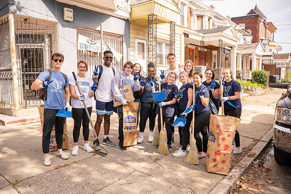 Students perform service on a city street