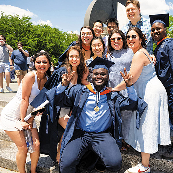 several members of the Class of 2020 pose in front of the Oreo sculpture on a sunny day