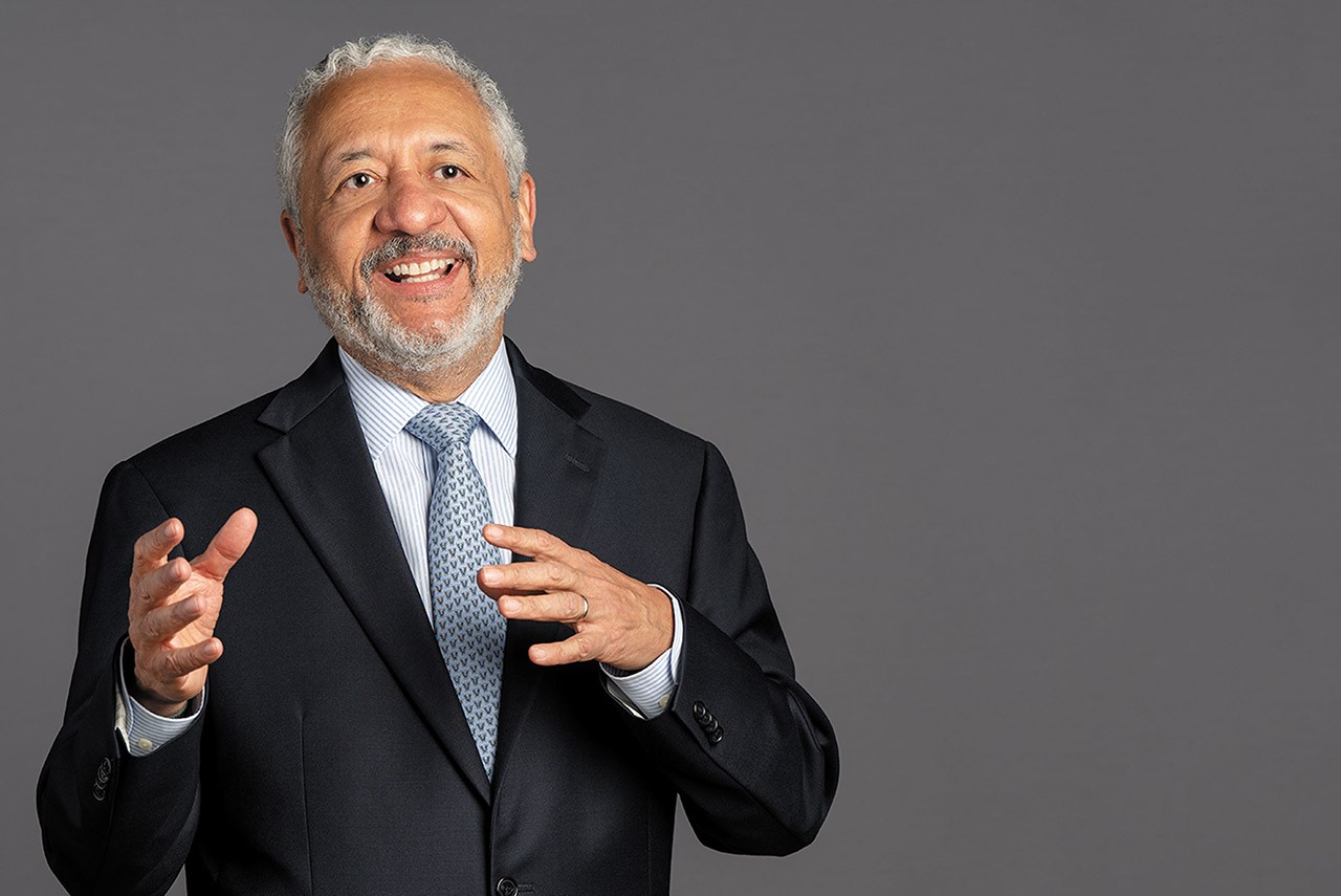 Dr. Ricaurte Vásquez Morales standing in a dark suit and tie, smiling 