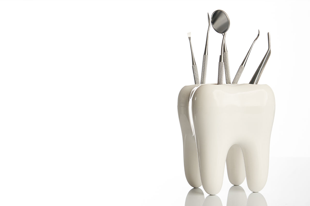dental tools are held in a giant white tooth 