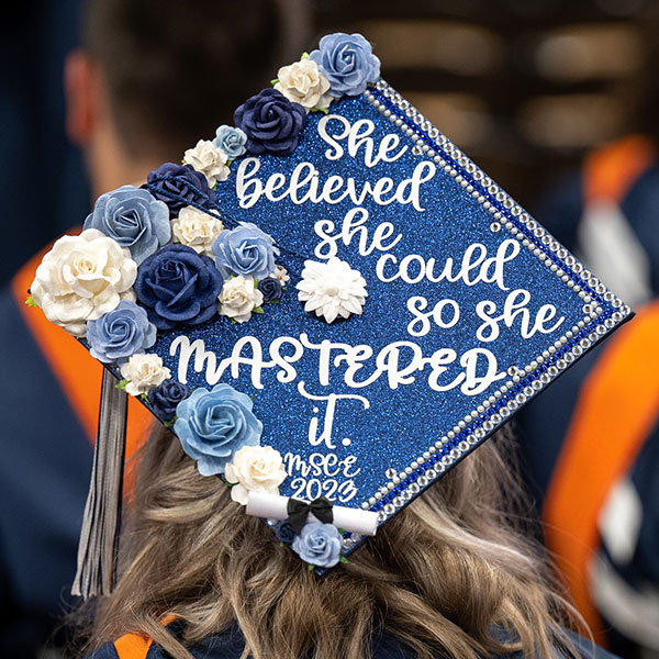 a blue graduation cap decorated with flowers and an inspirational quote