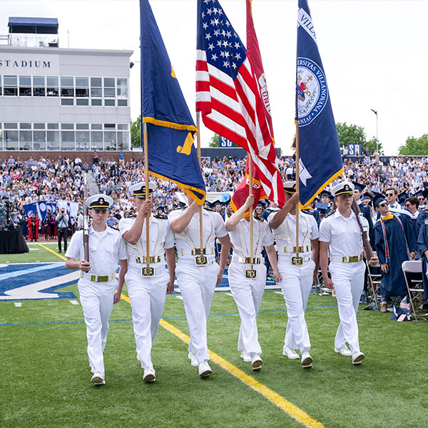six members of Villanvoa NROTC process with flags at Commencement