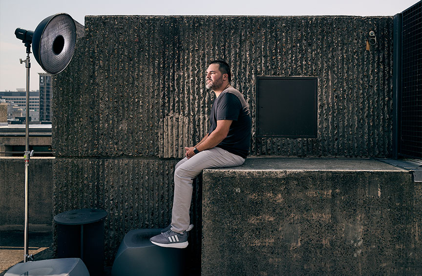 Vincent Guerrero sitting on a concrete structure on a rooftop