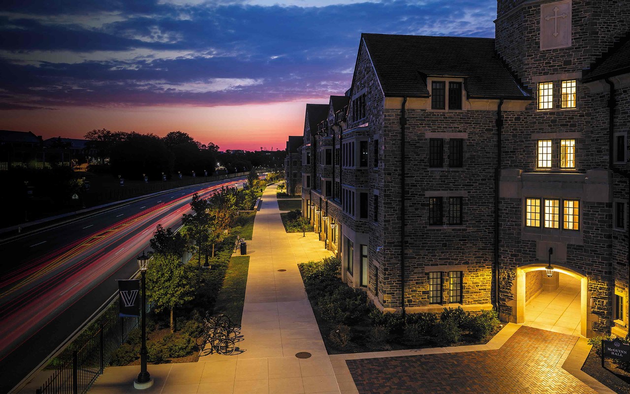 the exterior of The Commons student housing on Lancaster Avenue photographed at dawn