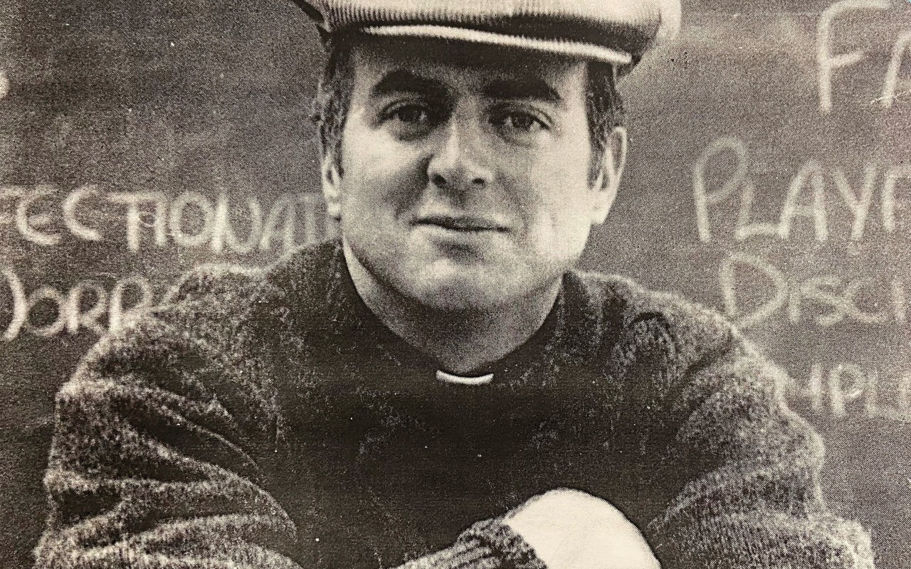portrait of the Rev. John P. Stack dressed casually in a classroom