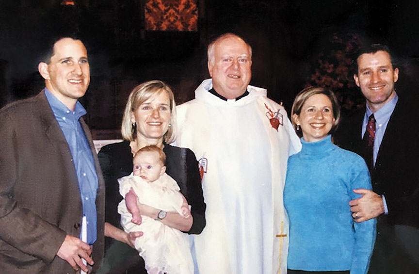 the Rev. John P. Stack in white liturgical vestment surrounded by the Healey family