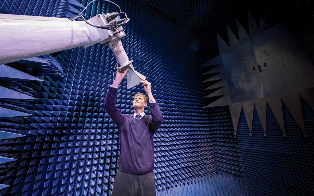 Student in Antenna Research Laboratory which has walls lined with three-dimensional purple cones