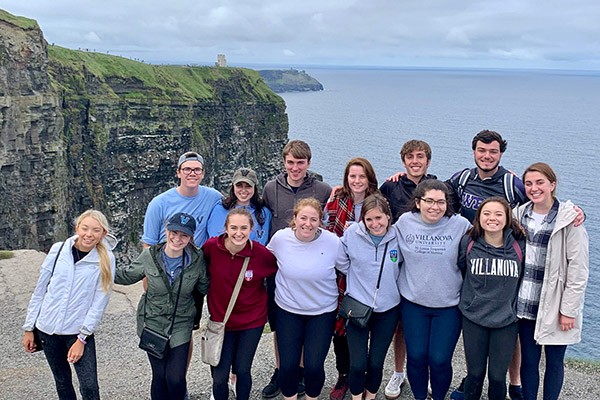 Villanova students pose for a photo by the cliffs of Ireland's coastline.