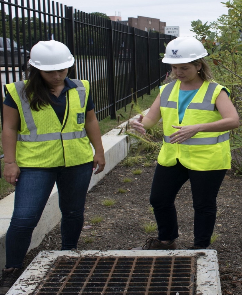 Engineering professor and student standing at stormwater drain