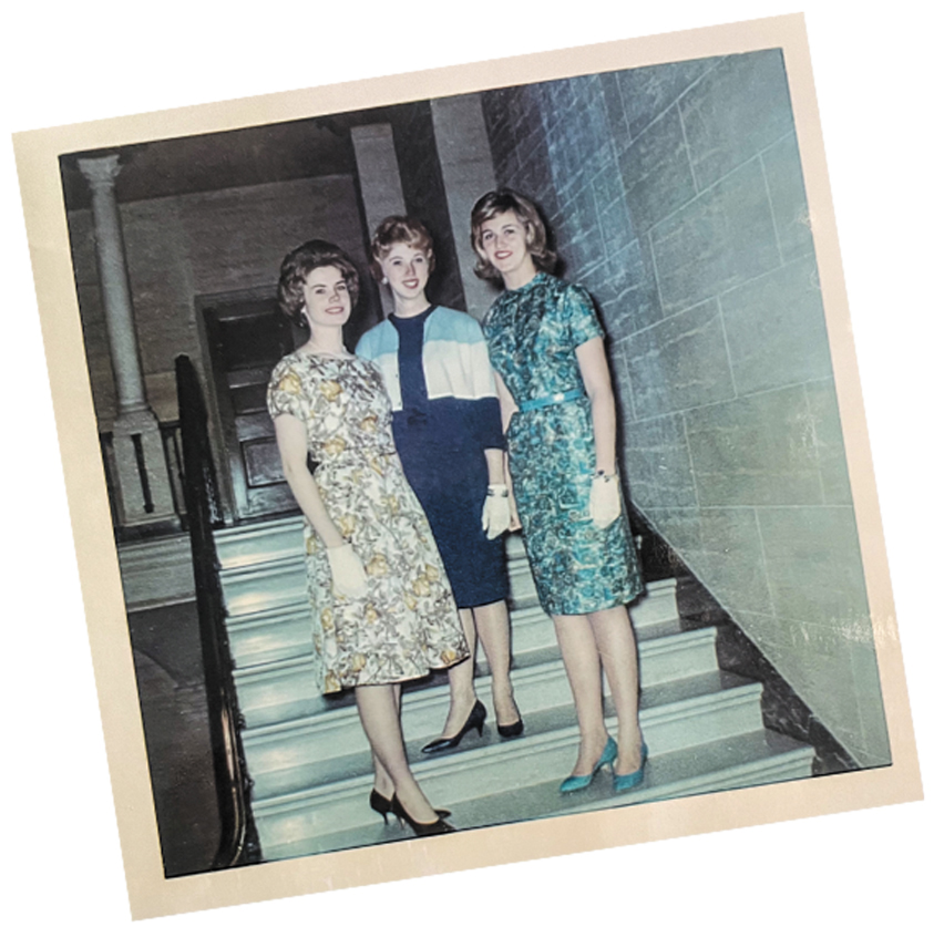 three Nursing students in the 1960s pose in dressy attire on a marble staircase