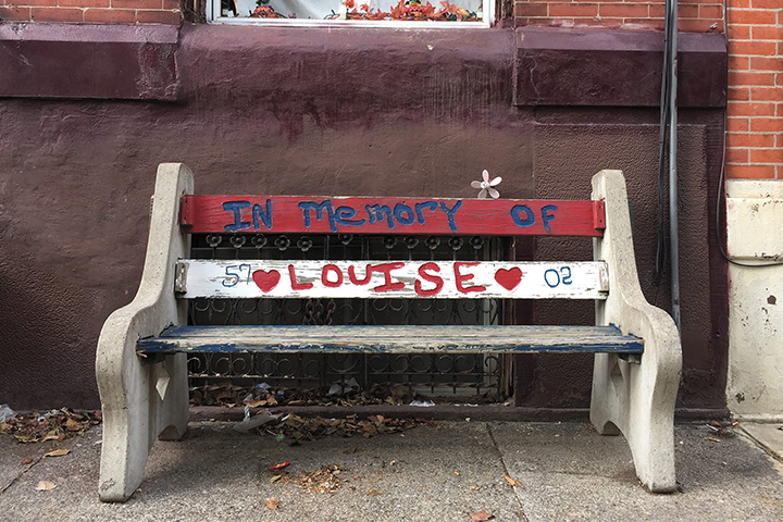 a sidewalk bench painted in memory of Louise